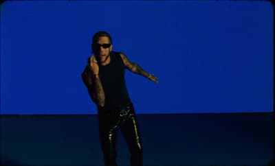 a man in a black tank top and shiny pants