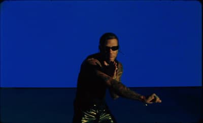 a man with a tattoo on his arm holding a tennis racquet