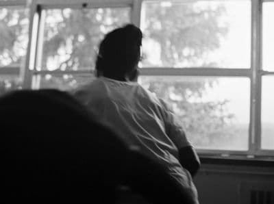 a man sitting in a chair looking out a window