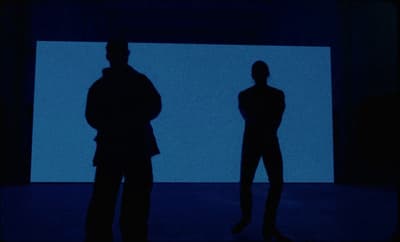 a couple of people that are standing in the dark