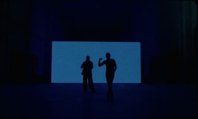 a couple of people standing in a dark room