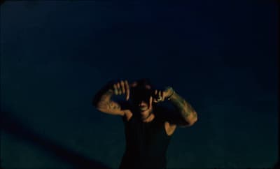 a man holding his hands behind his head
