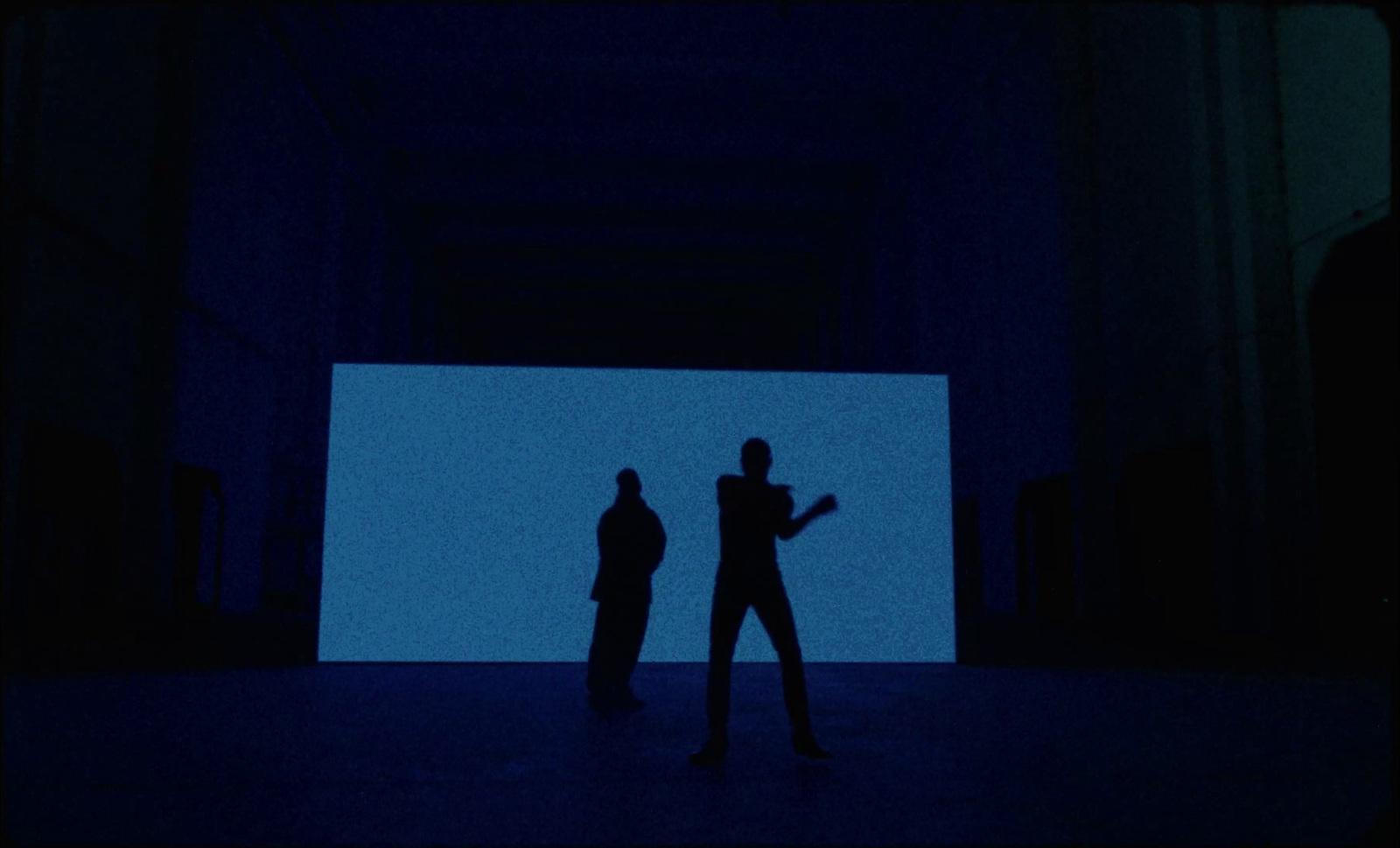 a couple of people standing in a dark room