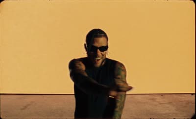 a man in sunglasses is holding a baseball bat