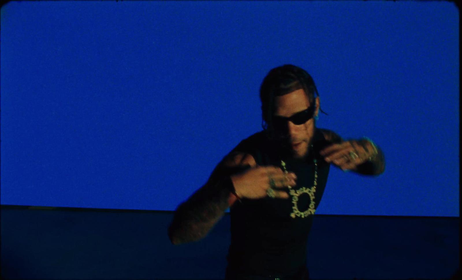 a man wearing sunglasses and a chain around his neck