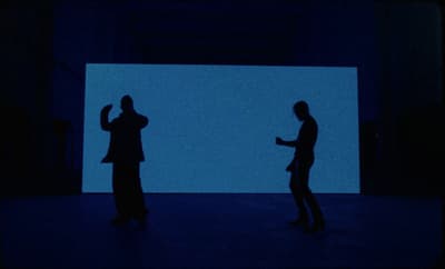 a couple of people that are standing in the dark