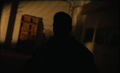 a man standing in a dark room with his back to the camera