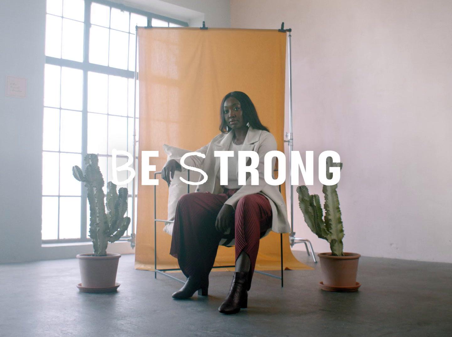 a woman sitting in a chair next to a cactus
