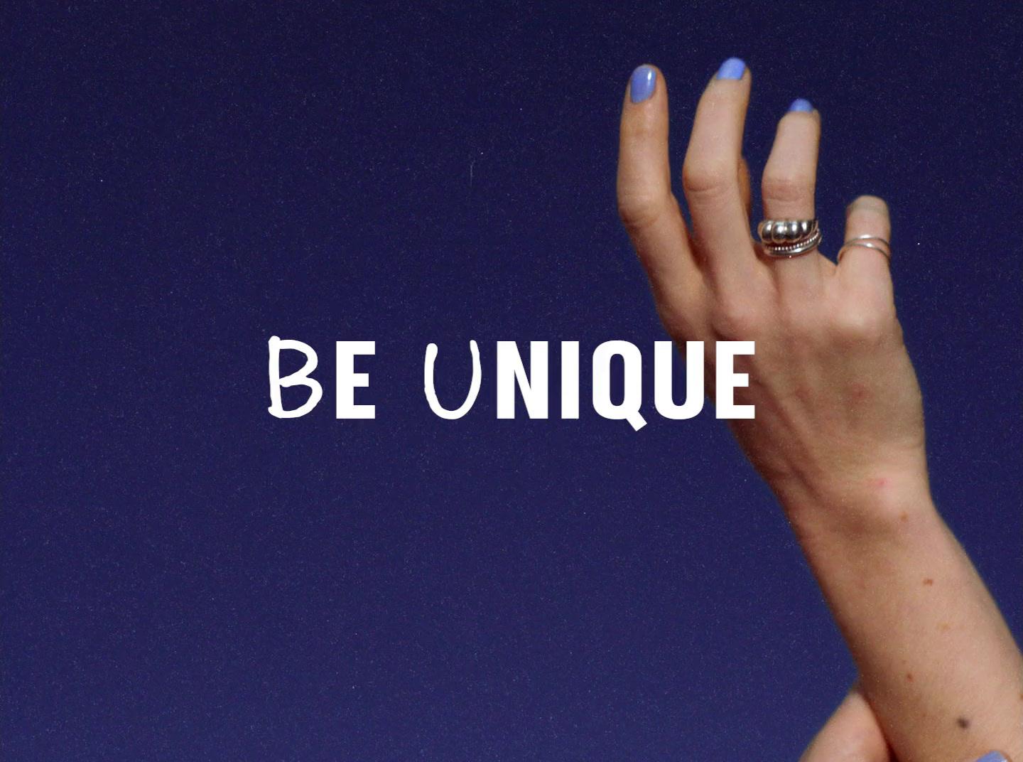 a woman's hand with a ring on it with the words be unique