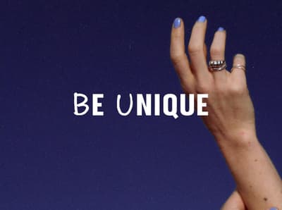 a woman's hand with a ring on it with the words be unique