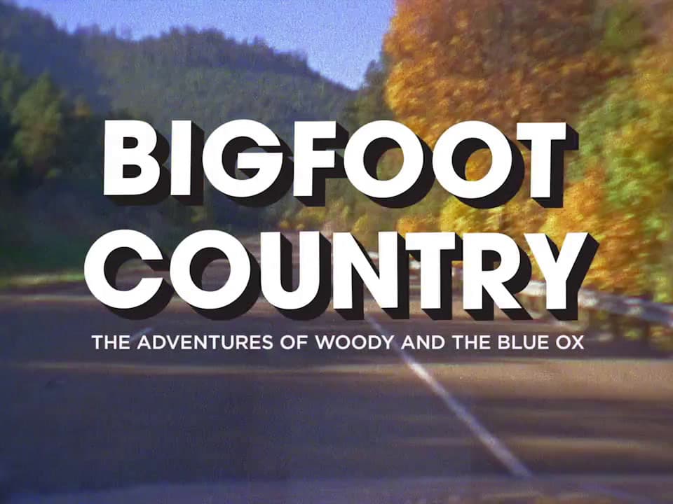 a bigfoot country movie title with trees in the background
