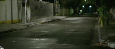 a man riding a skateboard down a street at night