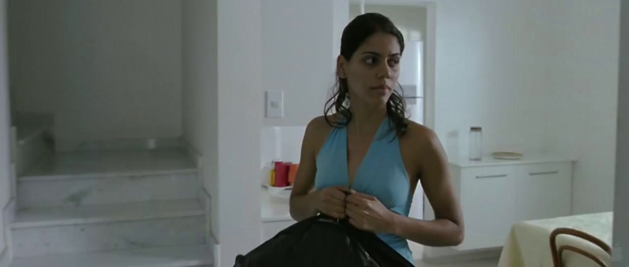 a woman in a blue tank top holding a black bag