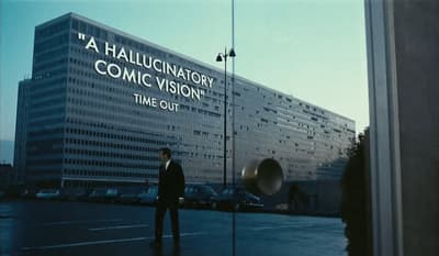 a man in a suit standing in front of a building