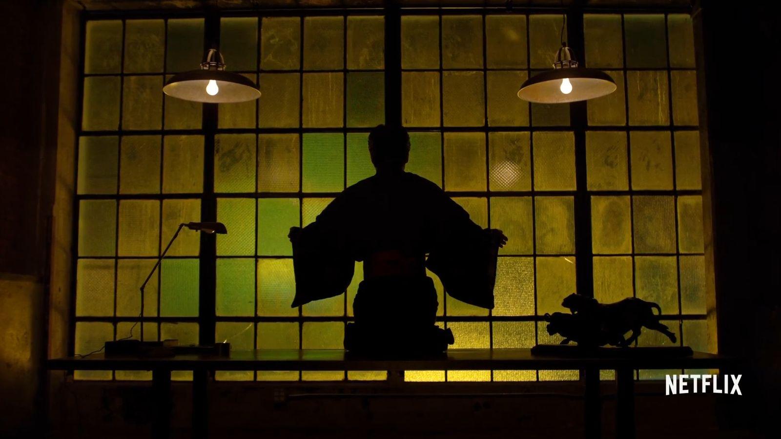 a silhouette of a person standing in front of a window
