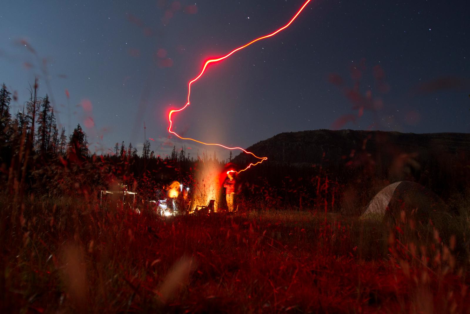 a couple of people standing in a field at night