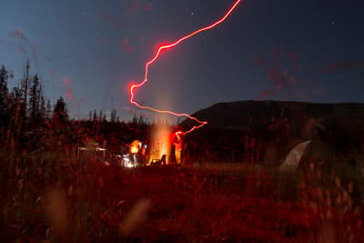 a couple of people standing in a field at night