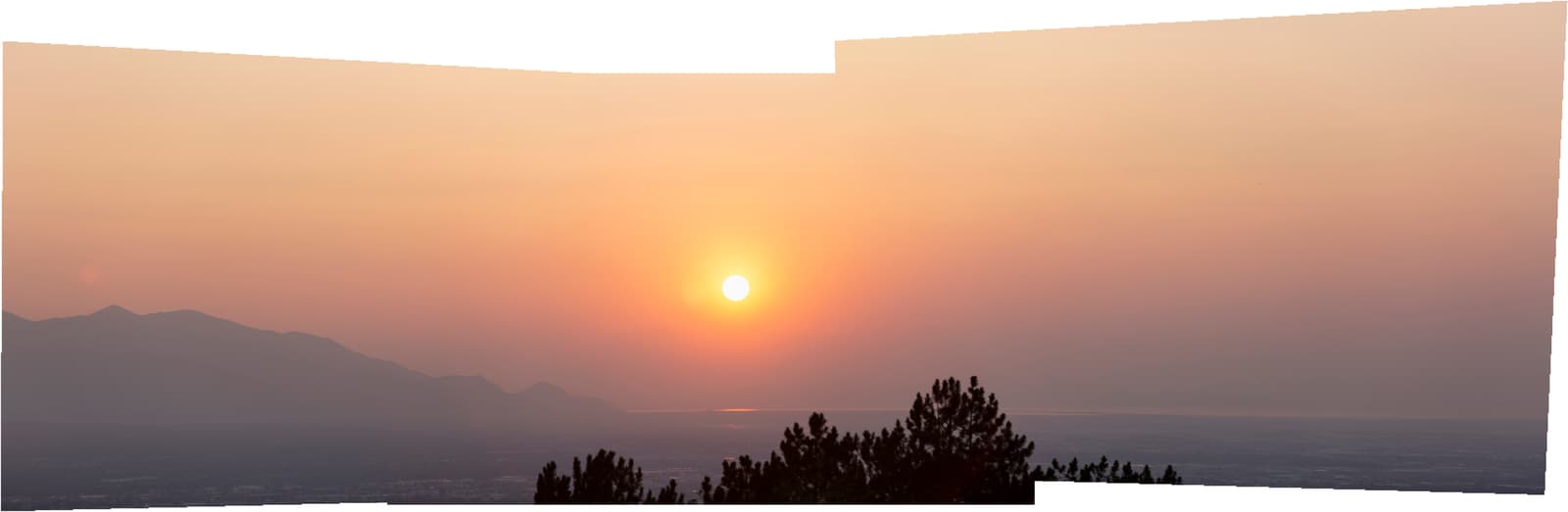 the sun is setting over a mountain range