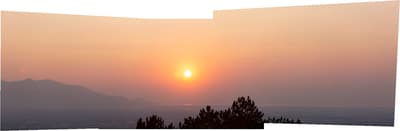 the sun is setting over a mountain range