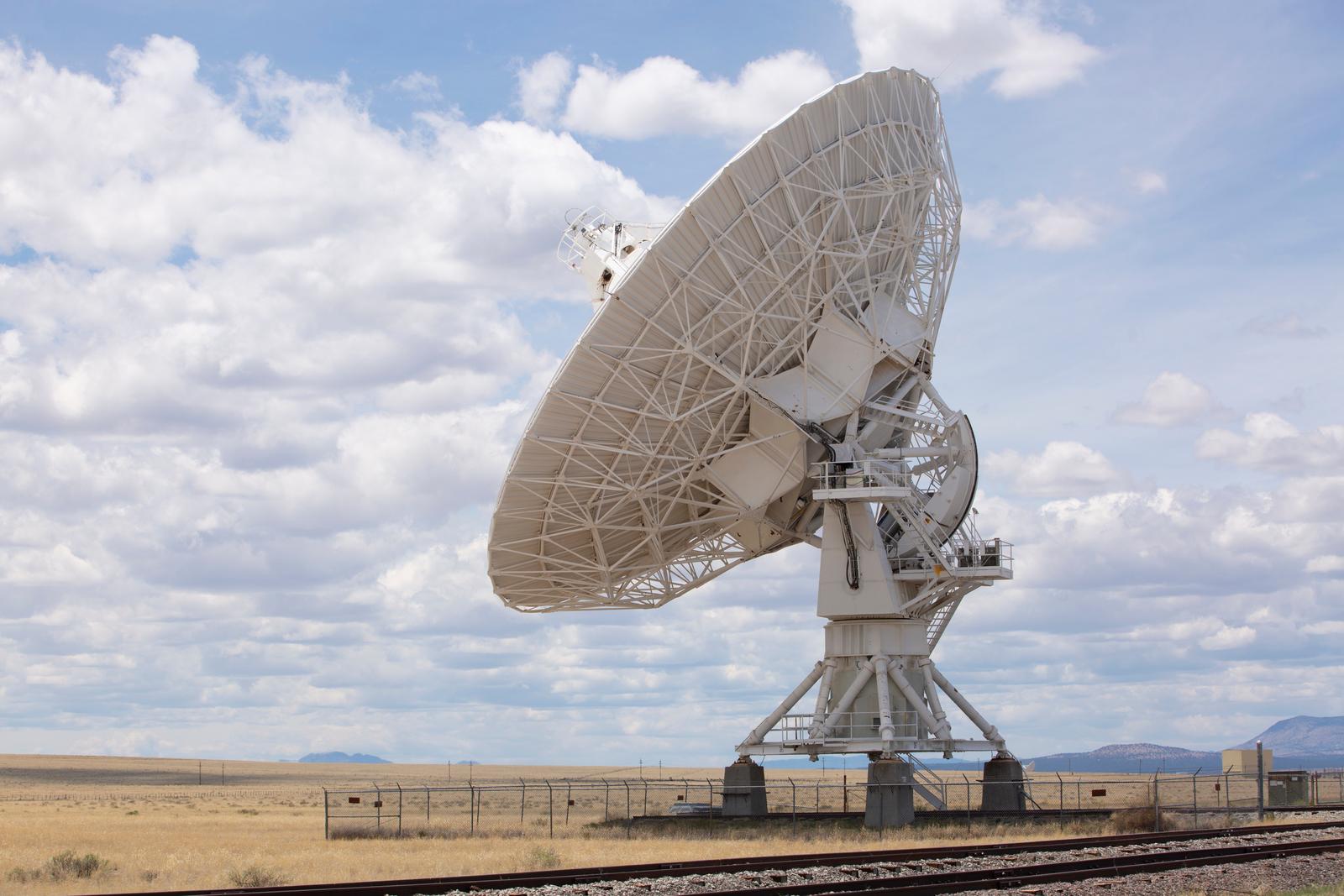 a large satellite dish sitting on top of a train track