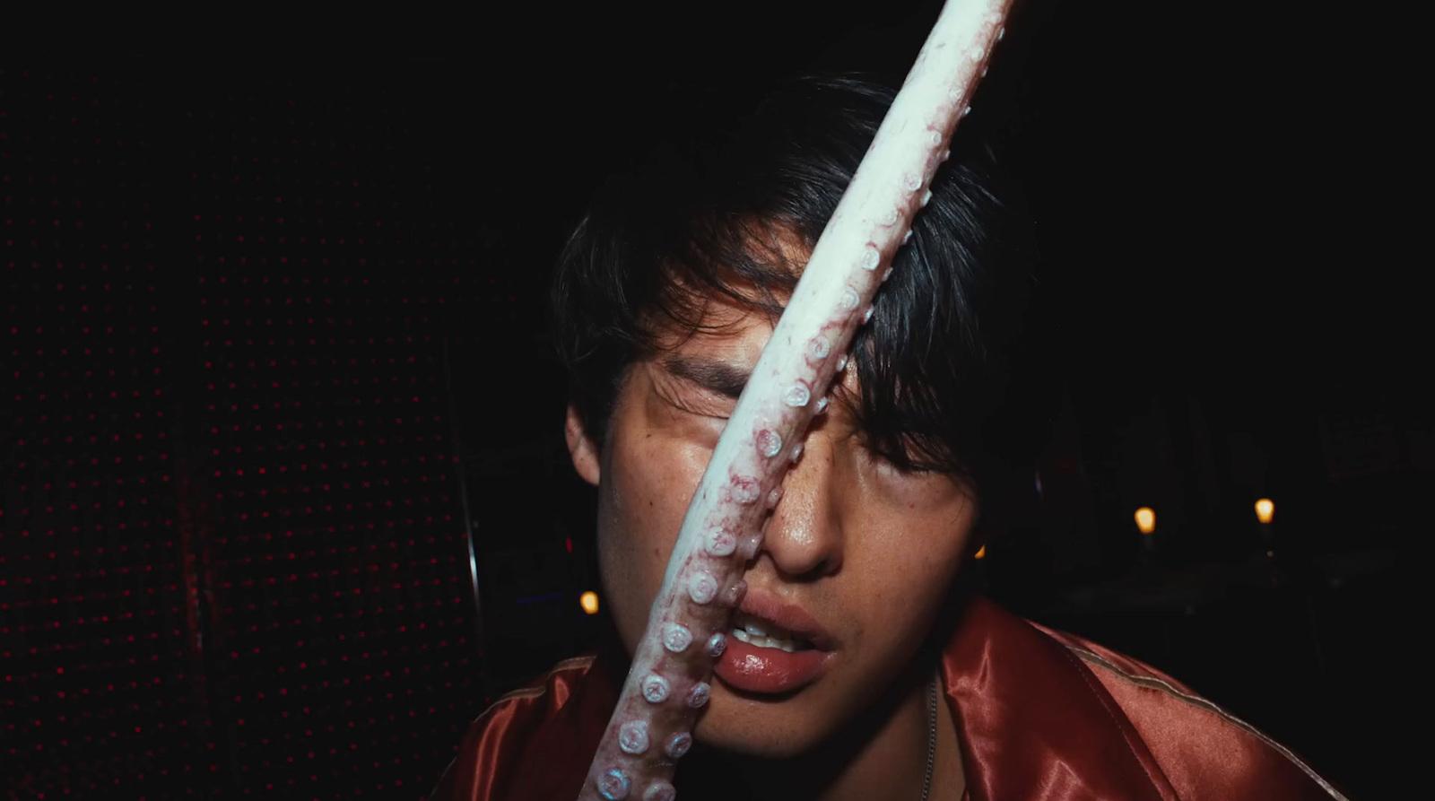 a young man holding an octopus in his hand