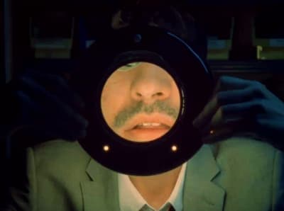 a man in a suit looking through a magnifying glass