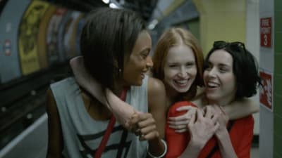 a group of women hugging each other in a subway station