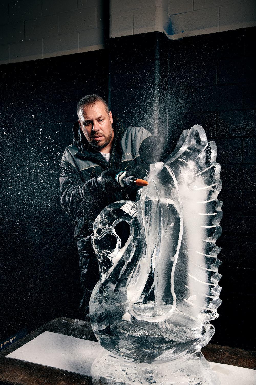 a man standing next to a large ice sculpture