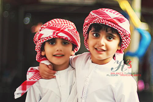 two young boys wearing red and white hats
