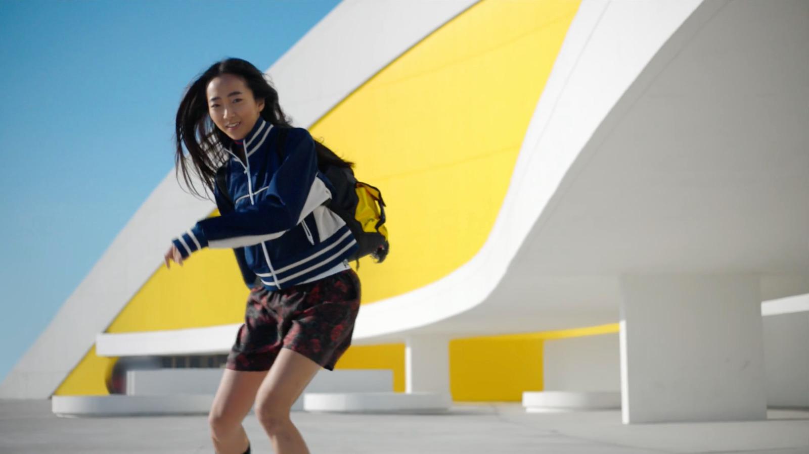 a woman riding a skateboard on top of a cement floor
