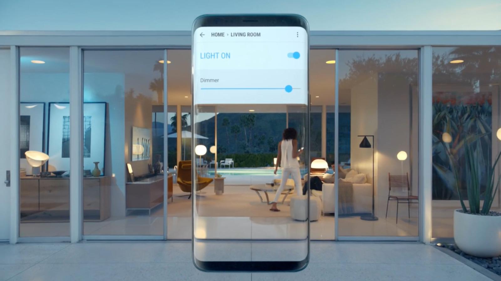 a cell phone with a woman walking in front of it