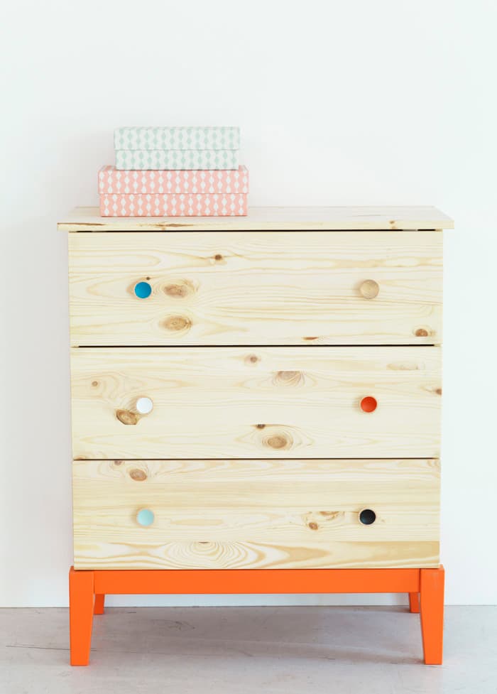 a wooden dresser with a stack of books on top of it