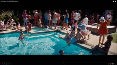 a group of people standing around a swimming pool