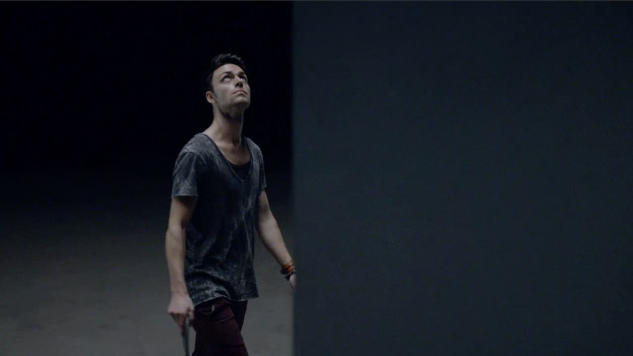 a man standing in a dark room looking up