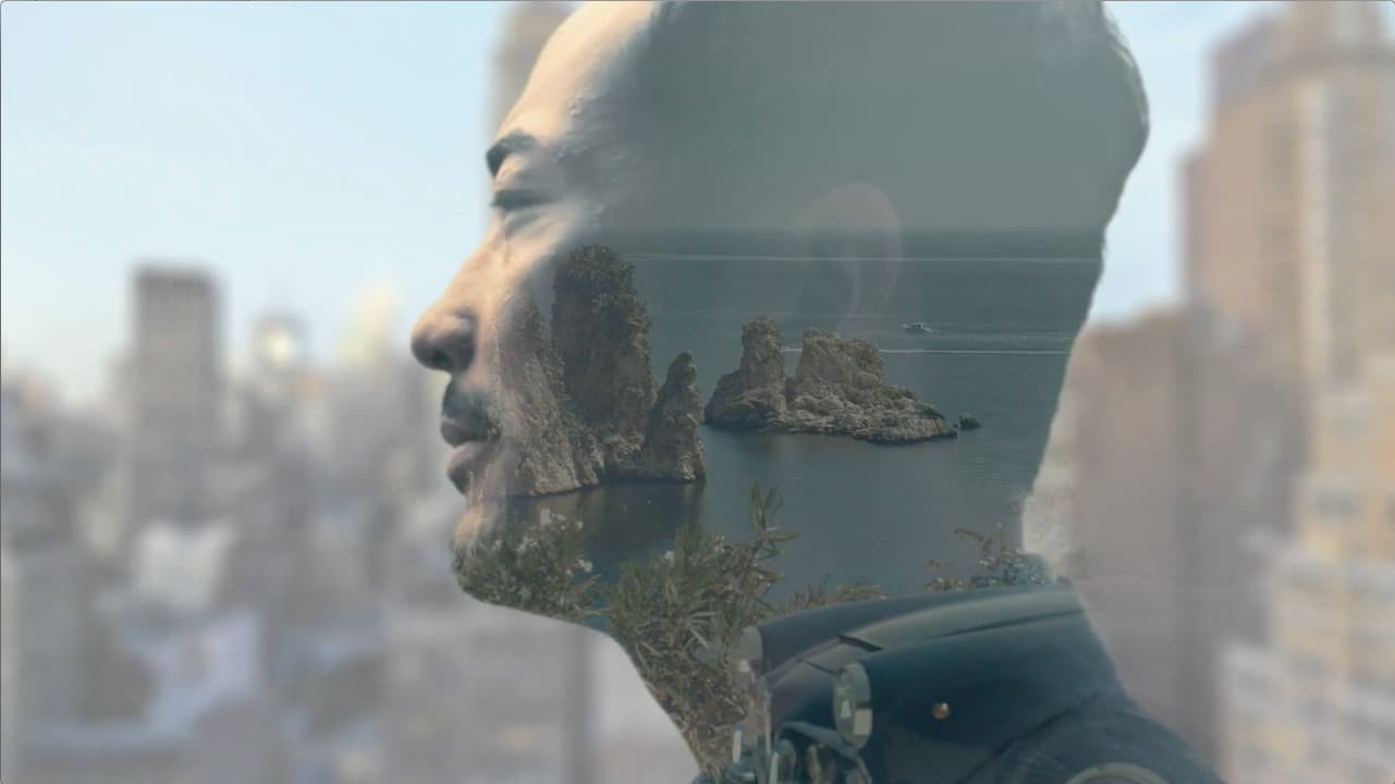 a man looking out of a window at a body of water