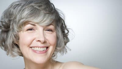 a woman with grey hair smiling for the camera