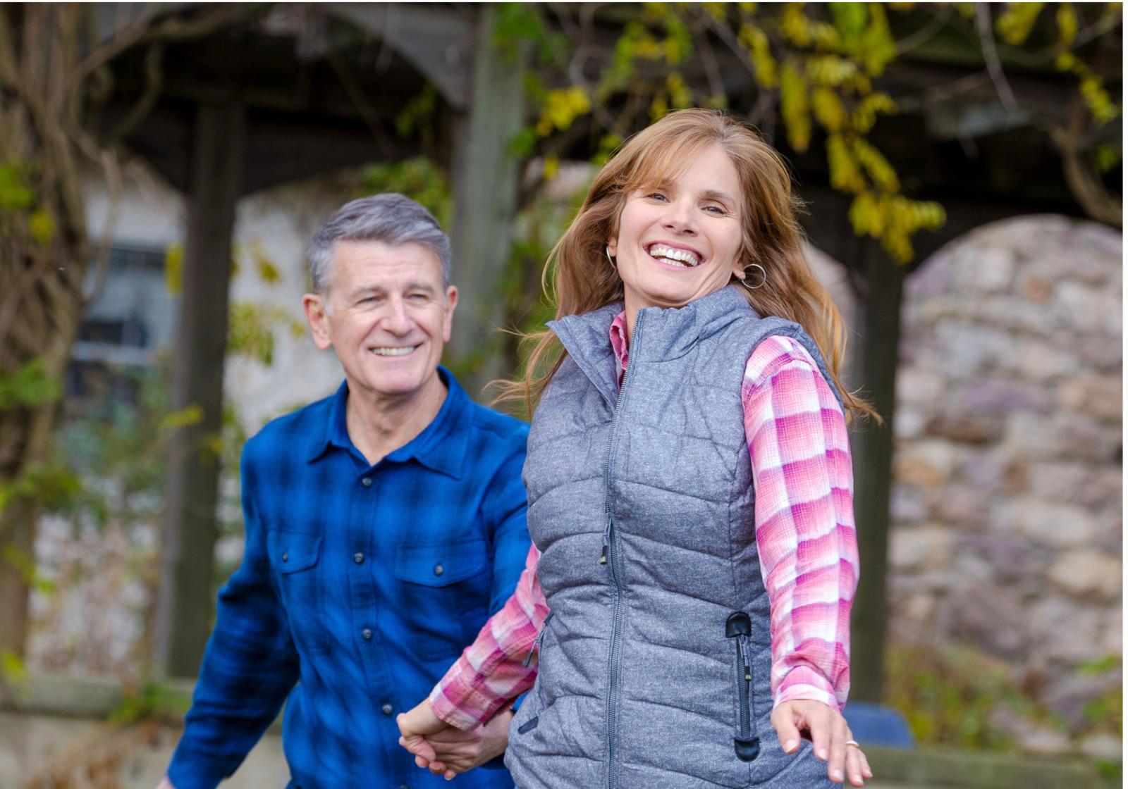 a man and a woman holding hands and smiling