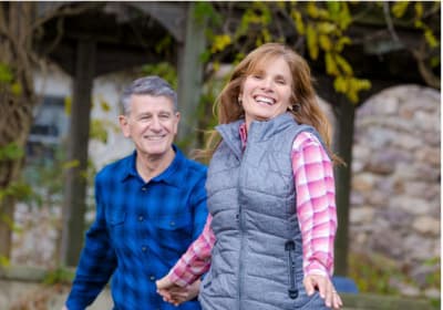 a man and a woman holding hands and smiling