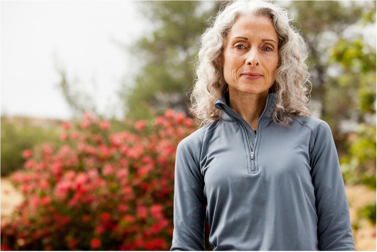 a woman standing in front of a bush