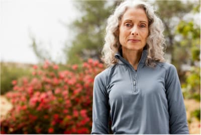 a woman standing in front of a bush