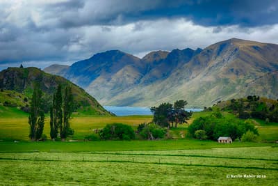 a green field with mountains in the background