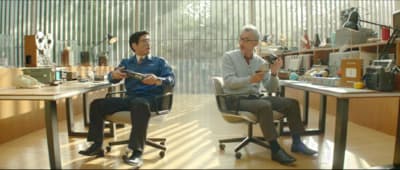 a couple of men sitting in chairs in a room