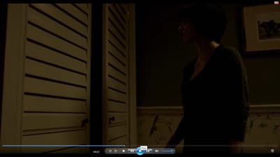a woman standing in front of a door in a dark room