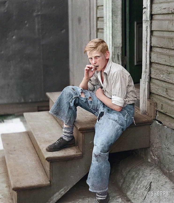 a young man sitting on a step talking on a cell phone