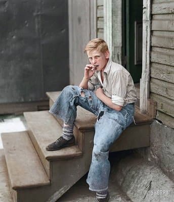 a young man sitting on a step talking on a cell phone