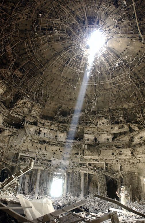 the ceiling of a destroyed building with a bright light shining through