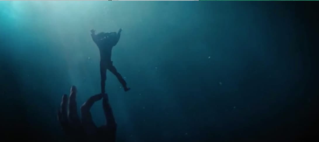 a hand reaching up into the water to grab something