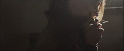 a woman standing in a dark room holding a cell phone