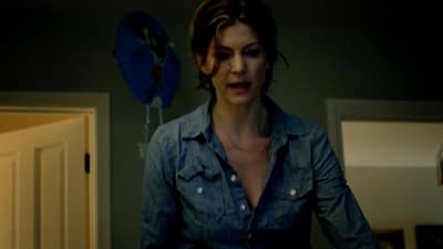 a woman in a blue shirt standing in a room