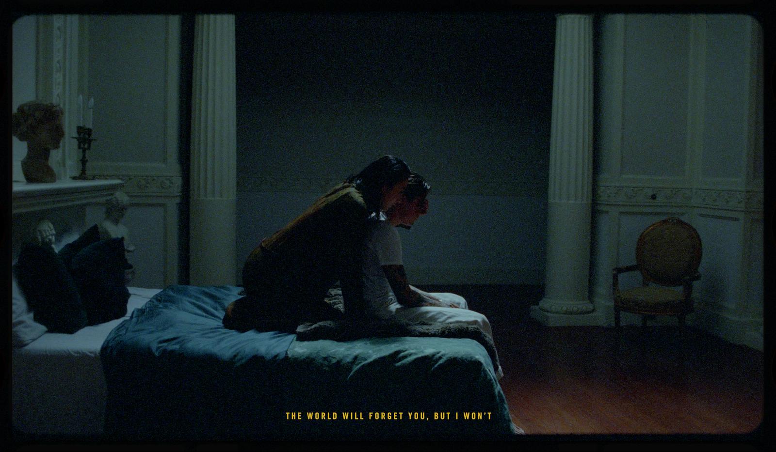 a person sitting on a bed in a room
